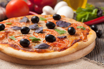 Italian pizza margherita with tomatoes, olive oil and basil