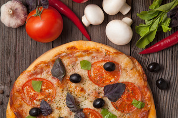 Italian pizza margherita with tomatoes, pepper, olives and basil