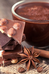 Stack of chocolate with nuts, cinnamon, star anise and coffee