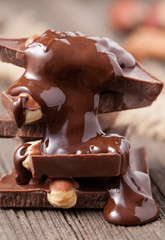 Stack of melted chocolate with nuts close up on wooden backgroun