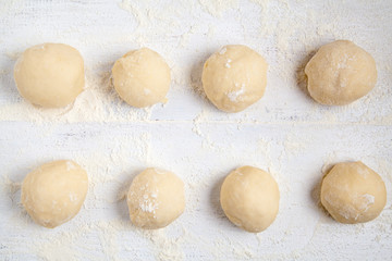 Fototapeta na wymiar Rolled balls of dough on white table