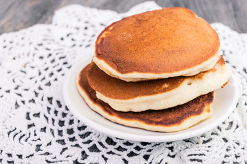 Fresh hot homemade pancakes slide in a  plate