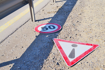 Road signs lying on the roadside