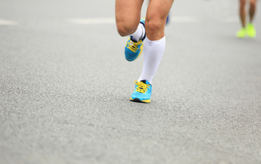 marathon runner legs running on city street