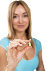 closeup on young woman showing pill