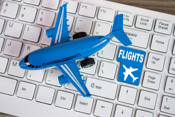 Toy airplane on keyboard online booking or purchase of plane tic