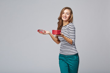 Young beautiful woman holding small red box. Studio portrait on