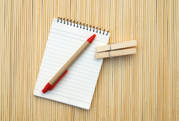 pen and notepad on bamboo matt