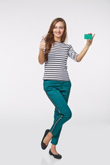 Happy smiling girl in casual clothing, showing blank credit card