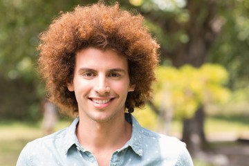 Young man smiling at camera in park