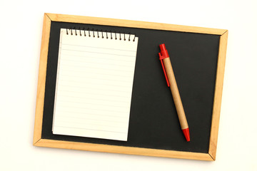 notepad and pen on blackboard