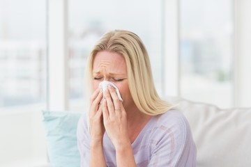Woman sneezing in tissue