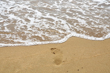 salt water flow to foot step on the beach