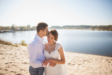 bride and groom, kissing on a beach