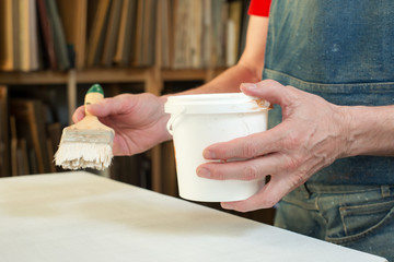 An artist priming canvas