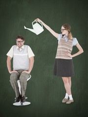Geeky hipster holding watering can above her boyfriend