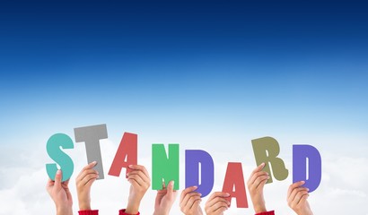 Composite image of hands holding up standard