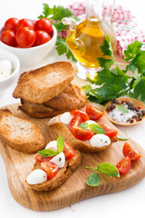 Fototapeta na wymiar toasts with mozzarella, basil and cherry tomatoes