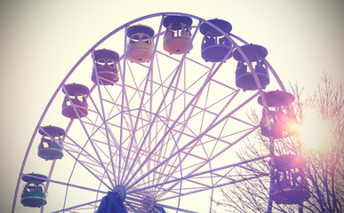 Retro vintage filtered picture of a ferris wheel at sunset.