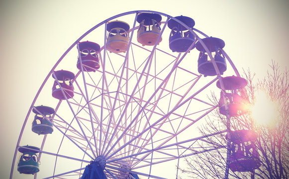 Retro vintage filtered picture of a ferris wheel at sunset.