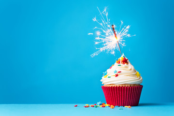 Cupcake with sparkler on blue