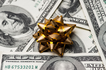 One hundred US dollars bills with holidays bow.