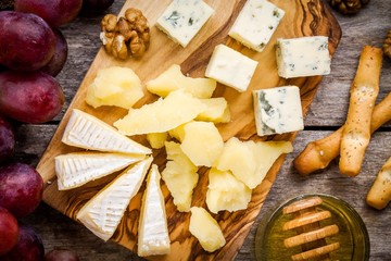 Camembert cheese, blue cheese closeup, bread sticks, grapes