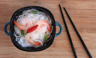 Rice vermicelli and shrimp in a bowl with chopsticks