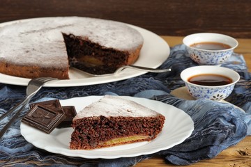 Chocolate cake and black tea on blue cloth