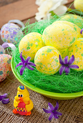 Easter eggs and flowers on wooden background