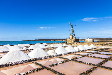 Naklejka premium salt piles in the saline of Janubio in Lanzarote with old toteen