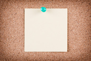 Reminder sticky note on cork board, empty space for text