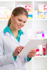 Happy female chemist in labcoat using digital tablet pc in store