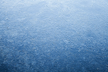 Thin ice layer of frozen river water