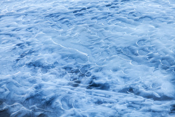 Blue melting ice surface on the frozen water