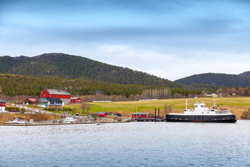 Obraz premium Norwegian small village with colorful wooden houses and ferry