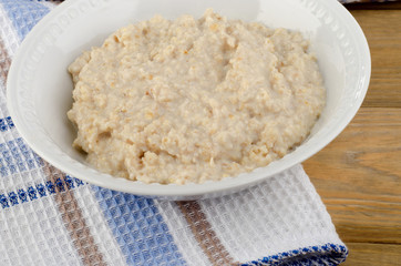 Bowl of oatmeal on wooden table. Healthy traditional breakfast
