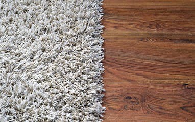 Two part split image of white shaggy carpet and wooden floor