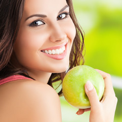 Young woman with apple, outdoor
