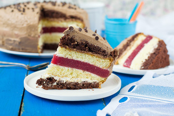 Biscuit cake with vanilla and chocolate cream and cherry jelly