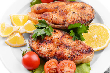 Tasty baked fish on plate close-up