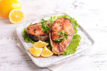 Tasty baked fish on plate on table close-up