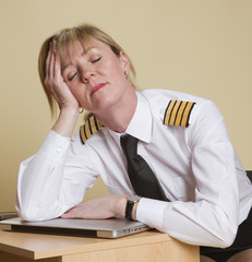 Tired female airline pilot wearing insignia of a captain © petert2