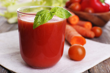 Glass of tomato juice with vegetables on wooden table close up