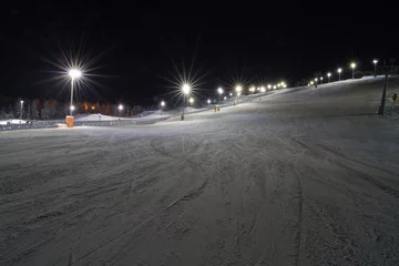 Foto op Aluminium Night skiing in Levi, Finland. Groomed ski slopes illuminated at night © hopsalka