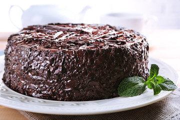 Tasty chocolate cake with cup of tea on table close up