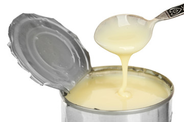 Obraz na płótnie Canvas Tin can of condensed milk with spoon isolated on white