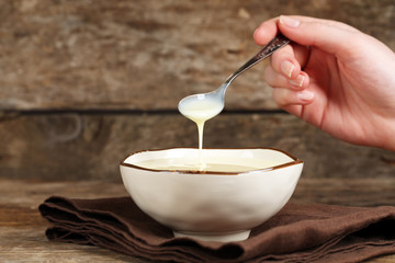 Bowl with condensed milk and spoon