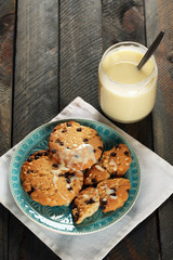 Cookies on plate with jar of condensed milk on wooden