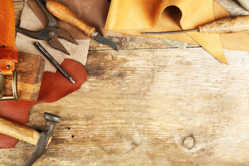 Leather and craft tools on wooden background